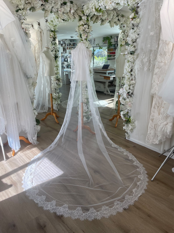 Long Chantilly lace mantilla wedding veil as seen on a mannequin in the Harriett Falvey bridal studio