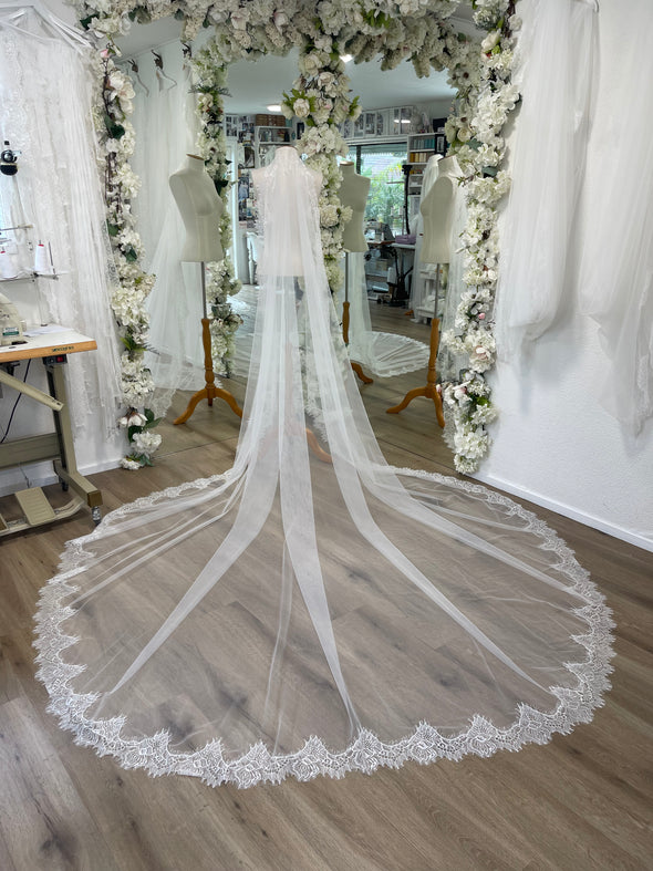 Extra wide tulle and chantilly lace mantilla veil as seen on a mannequin in Harriett Falvey bridal studio.