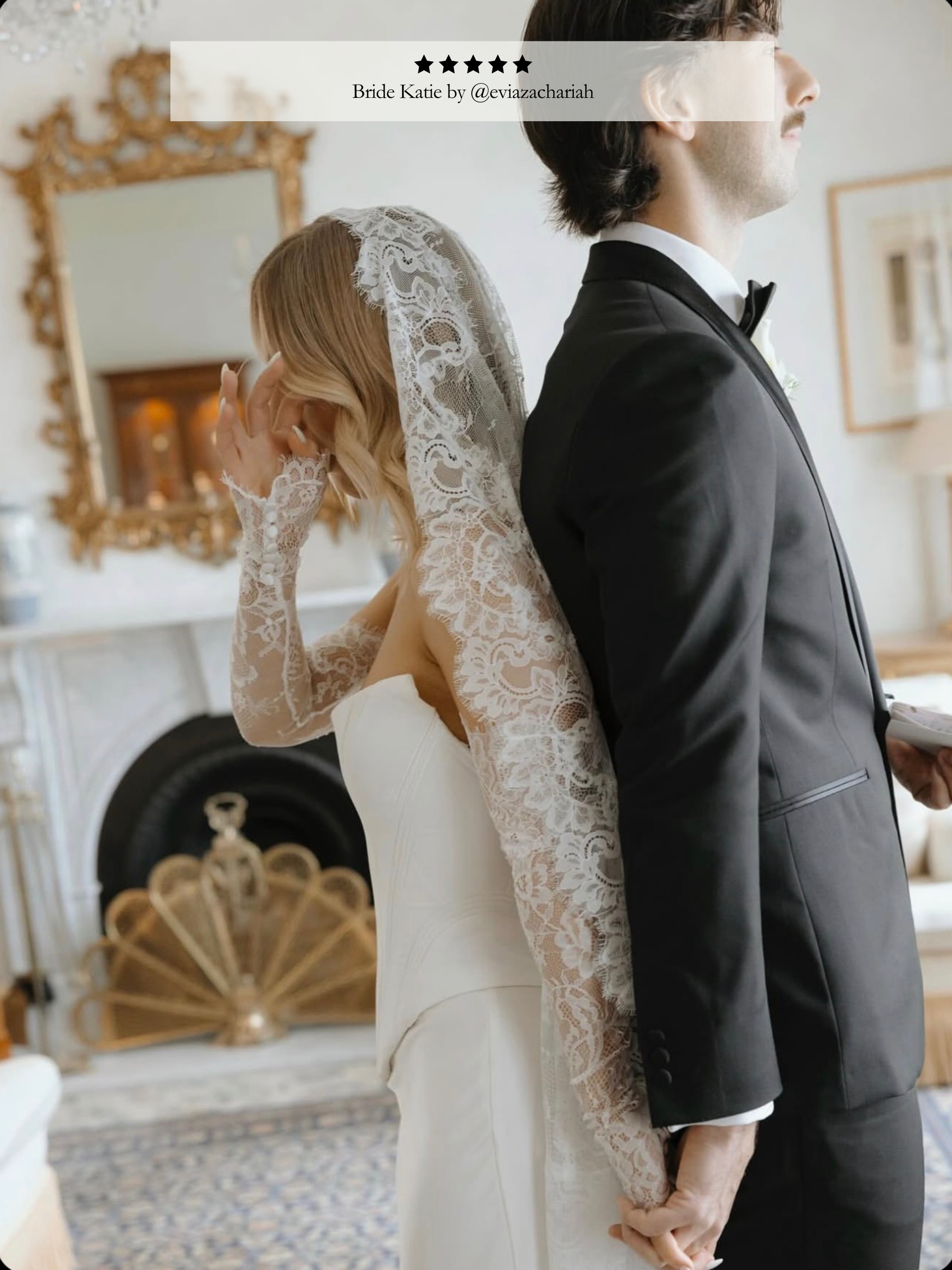 Man in a suit and woman in a wedding dress with a long veil in a decorated room.
