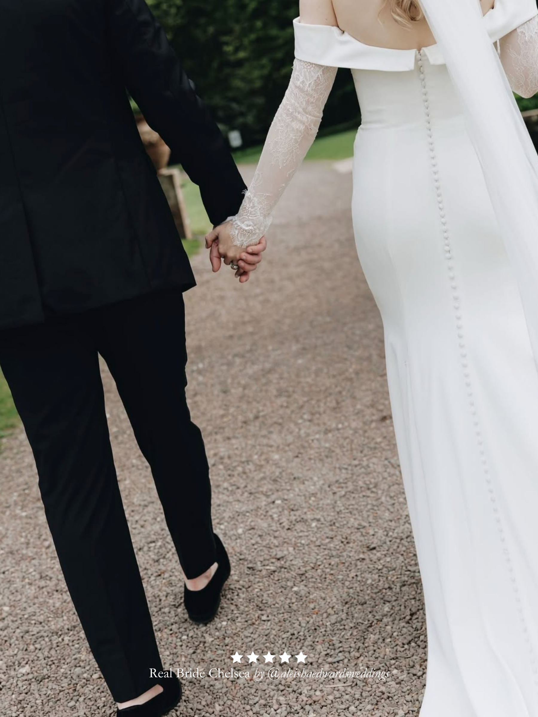 Two people holding hands on a path, one in a black suit and the other in a wedding dress and Harriett Falvey double edged lace bridal sleeves.