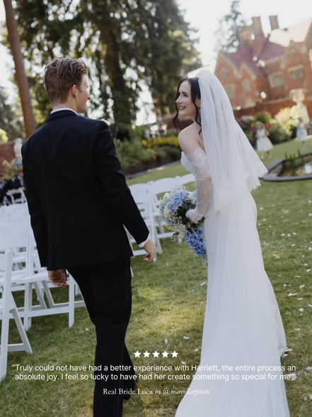 Wedding couple standing in a garden with a building in the background. Bride wearing a Harriett Falvey blusher veil and double edged lace gloves.